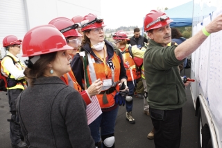 Portland Neighborhood Emergency Teams volunteers gathered to receive instructions from a leader pointing to a whiteboard